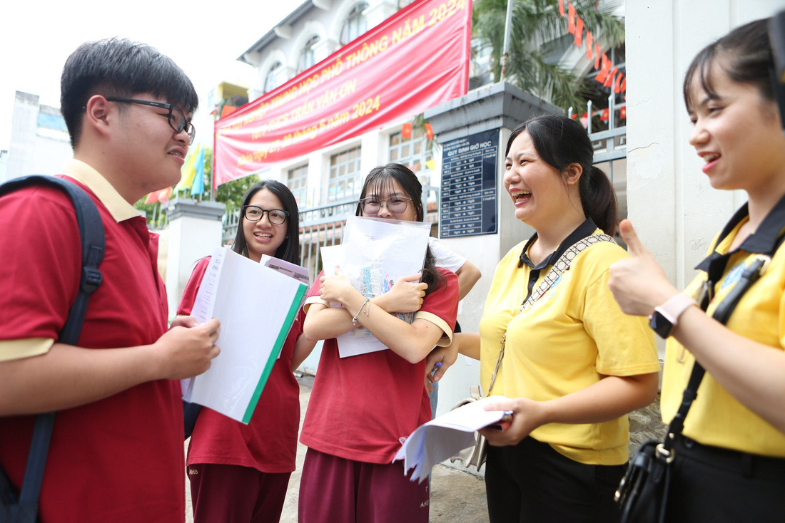 Cô Minh Hiền (giáo viên Trường quốc tế Á Châu) túc trực ở điểm thi THCS Trần Văn Ơn (quận 1, TP.HCM) động viên các học sinh của mình trước giờ thi môn toán chiều 27-6 - Ảnh: PHƯƠNG QUYÊN