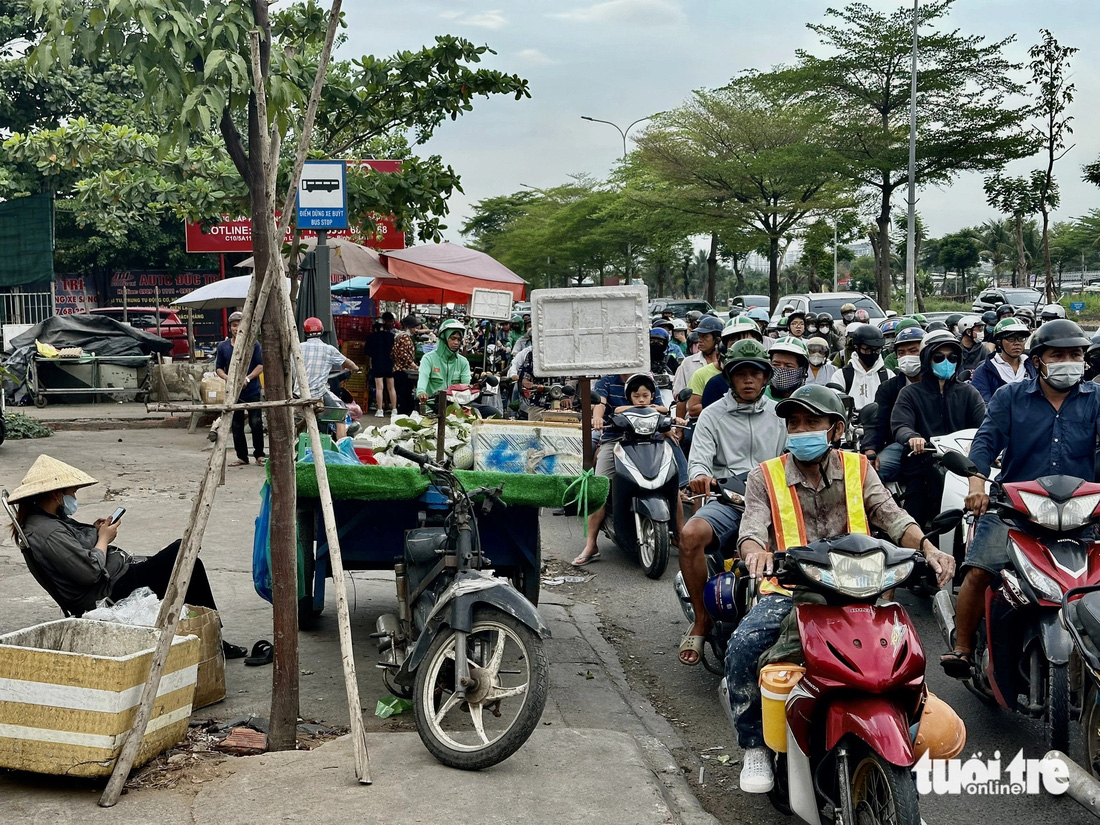 Vỉa hè ngã tư Nguyễn Văn Linh - Phạm Hùng bị hàng rong, xe ba gác chiếm dụng - Ảnh: NGỌC QUÝ