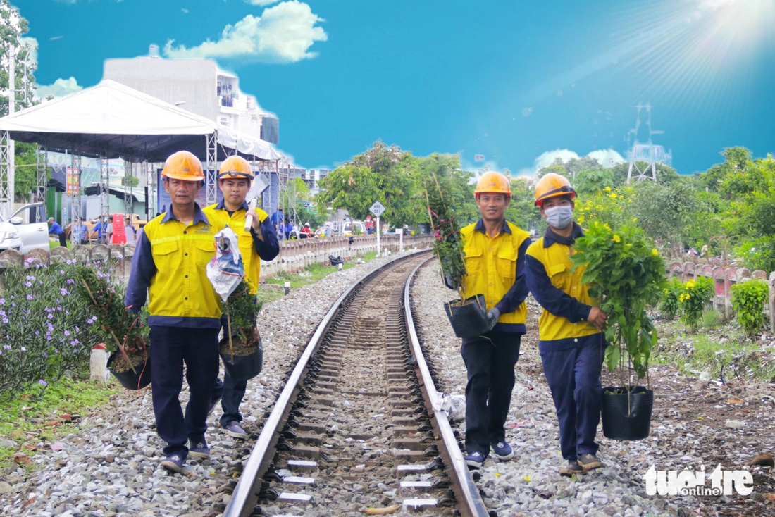Nhân viên thuộc Tổng công ty Đường sắt Việt Nam ra quân trồng hoa dọc hai bên đường sắt thuộc khu vực phường Hiệp Bình Chánh, TP Thủ Đức - Ảnh: TIẾN QUỐC