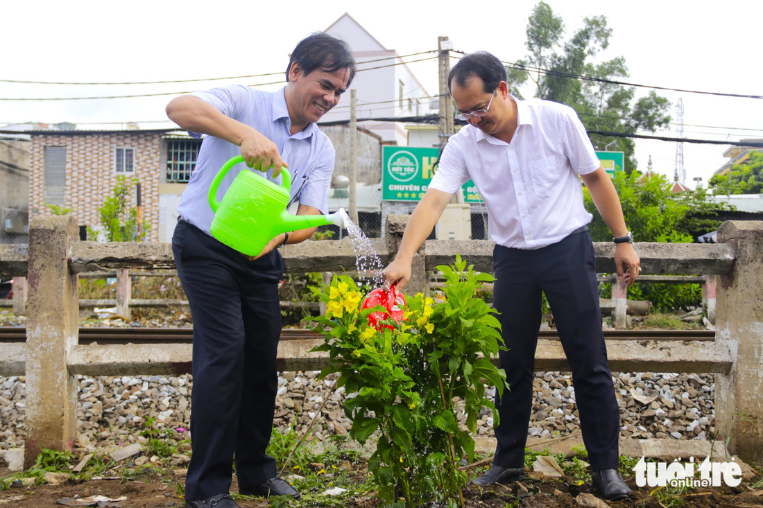 Các lãnh đạo Tổng công ty Đường sắt Việt Nam tham gia trồng hoa, tưới nước tại ngày ra quân - Ảnh: TIẾN QUỐC