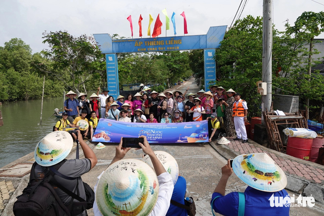 Cả đoàn chụp ảnh lưu niệm trước cổng chào ở đảo Thiềng Liềng - Ảnh: T.T.D.