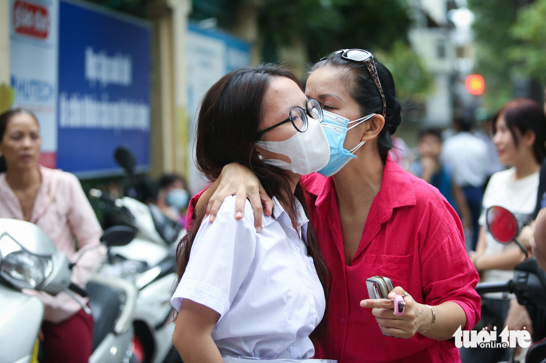 Nữ sinh người Việt gốc Hàn Sim Bo Mim được mẹ thơm má trước khi vào phòng thi môn toán ở điểm thi THPT Trưng Vương (quận 1). "Dù là con lai nhưng bé rất yêu thích tiếng Việt và văn học Việt Nam, nên chọn nguyện vọng thi chuyên văn", mẹ Bo Mim cho biết