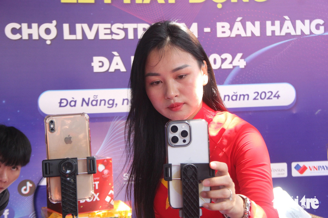 Hướng dẫn livestream bán hàng trước chợ Cồn, Đà Nẵng - Ảnh: TRƯỜNG TRUNG