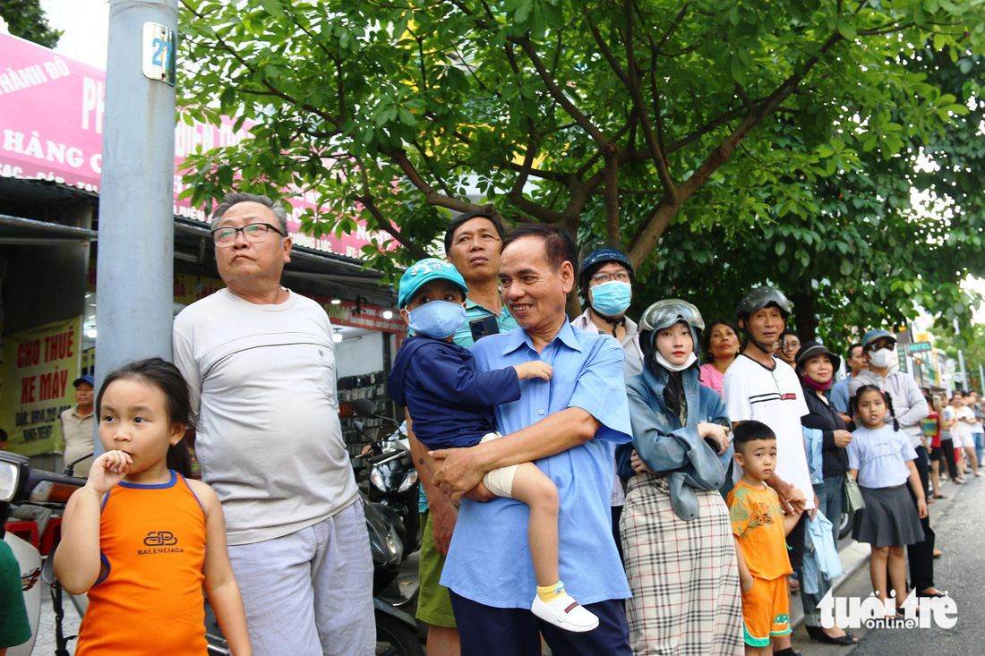 Người dân, du khách xứ Huế thích thú đón xem đoàn rước lễ hội đường phố - Ảnh: NHẬT LINH