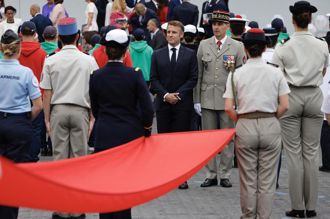 Tổng thống Pháp Emmanuel Macron và Thống đốc quân đội Paris, Trung tướng Christophe Abad, tham dự cuộc diễu binh nhân Ngày Quốc khánh trên đại lộ Foch ở Paris ngày 14-7 - Ảnh: AFP