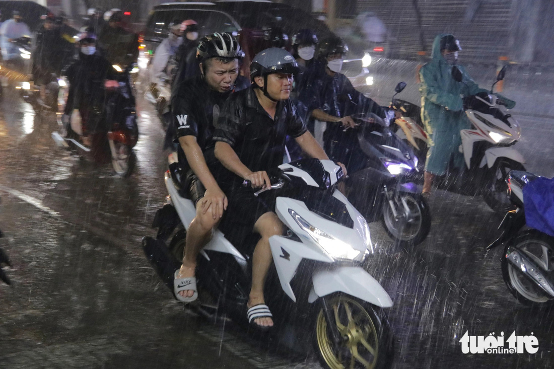 Người dân quên mang áo mưa, đội mưa về nhà sau giờ làm - Ảnh: TIẾN QUỐC