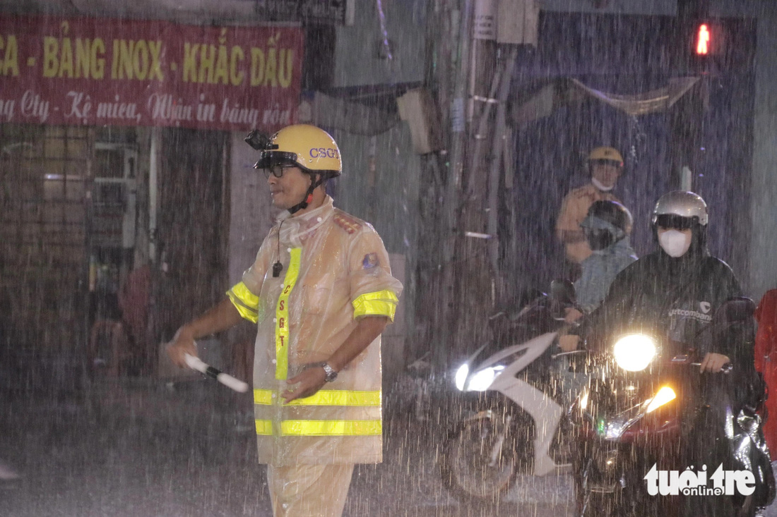 Lực lượng CSGT đội mưa điều phối giao thông tại đường Thống Nhất - Ảnh: TIẾN QUỐC