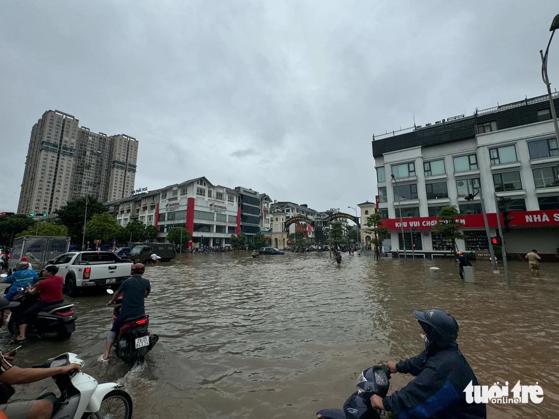 Nước bủa vây lối vào khu đô thị Geleximco Lê Trọng Tấn - Ảnh: THÀNH CHUNG