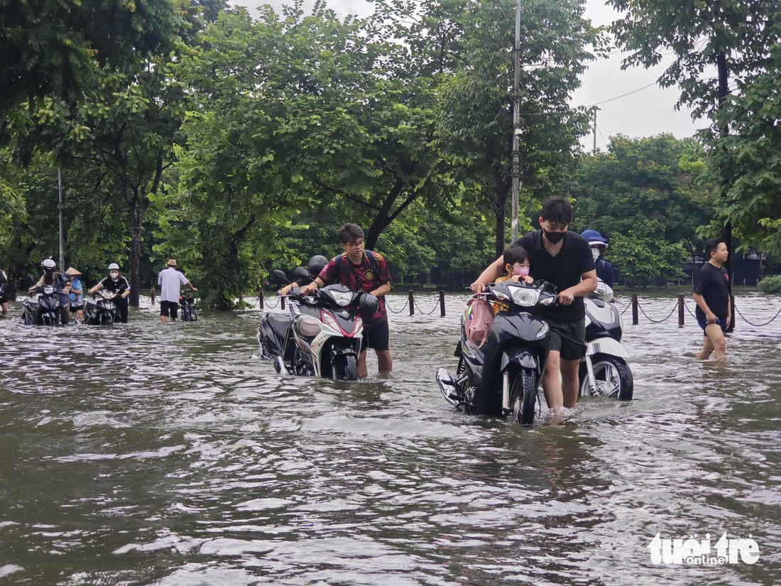 Khu vực hồ Văn Quán (Hà Đông, Hà Nội) nước dưới lòng hồ tràn mặt đường, ngập sâu khiến nhiều phương tiện giao thông khó khăn - Ảnh: DƯƠNG LIỄU