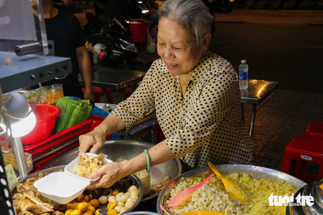 Chủ quán xôi Number One xới xôi cho khách - Ảnh: ĐĂNG KHƯƠNG