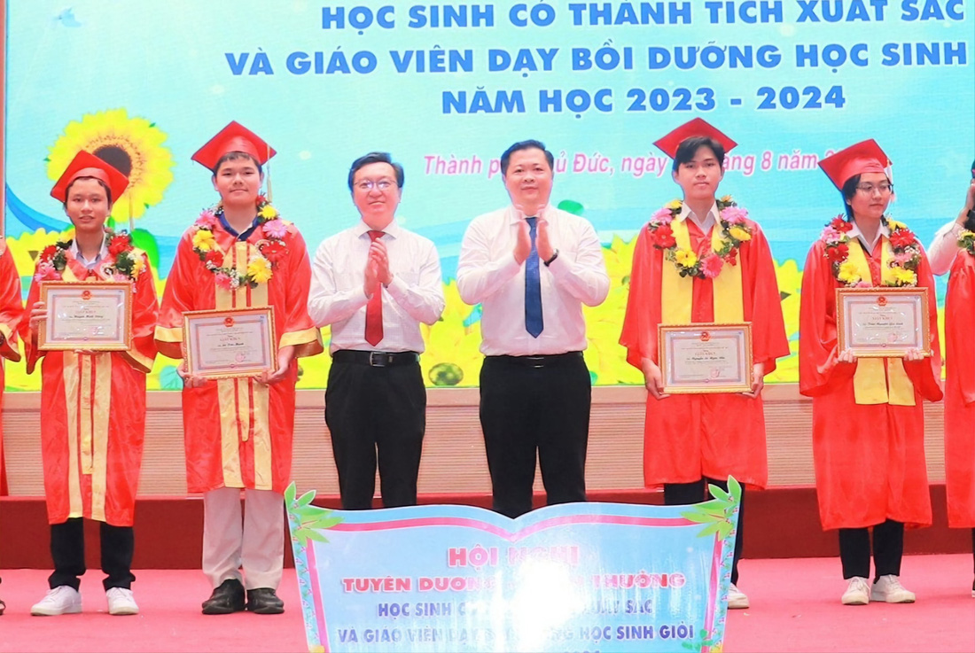 Ông Nguyễn Bảo Quốc, phó giám đốc Sở Giáo dục và Đào tạo TP.HCM (thứ ba từ trái sang) và ông Nguyễn Thái Vĩnh Nguyên, trưởng Phòng Giáo dục và Đào tạo TP Thủ Đức (thứ tư từ trái sang) trao bằng khen cho các học sinh giỏi - Ảnh: V.N