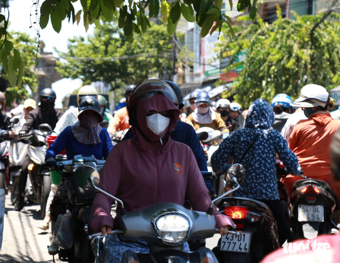 Dừng chờ tàu ở làn ngược chiều, khi tàu đi qua, người phụ nữ nhích sang phải tông vào chân người đi xe đối diện - Ảnh: ĐOÀN NHẠN