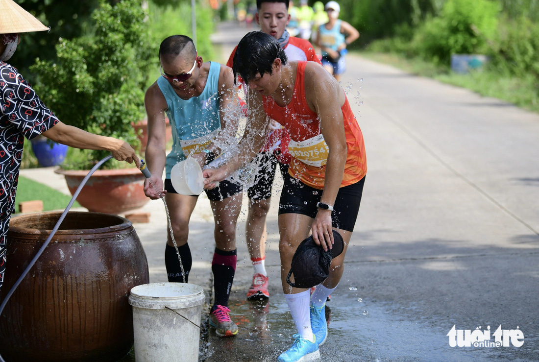 Người dân tưới nước, làm mát cho các runner ở GreenUP Marathon - Long An Half Marathon 2024- Ảnh 3.