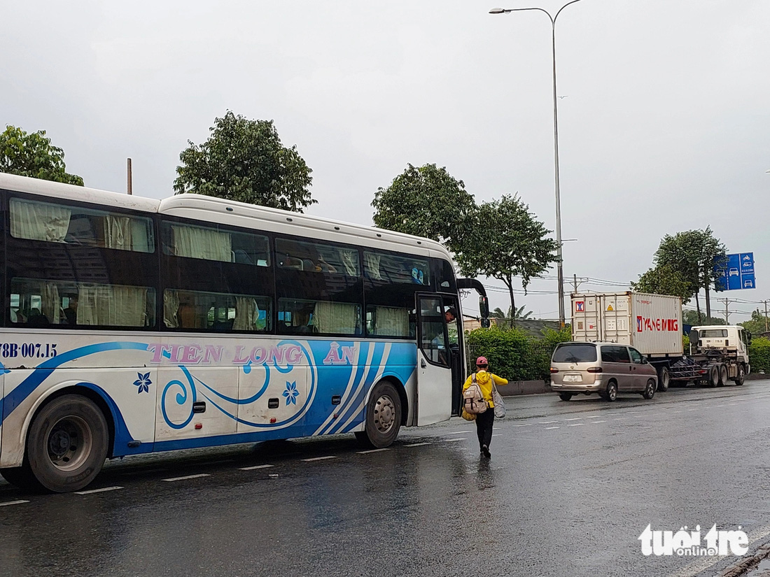 Nhiều nhà xe bất chấp nguy hiểm, đón khách chớp nhoáng ngay giữa quốc lộ 1, ngày 2-8 - Ảnh: ĐÌNH KHẢI