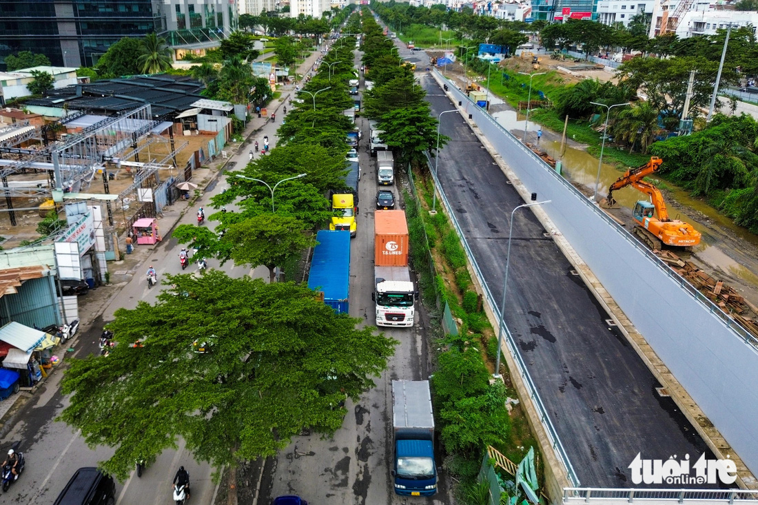 Mặt đường Nguyễn Văn Linh hỏng nặng, xe tải cũng sụp ổ gà - Ảnh 7.