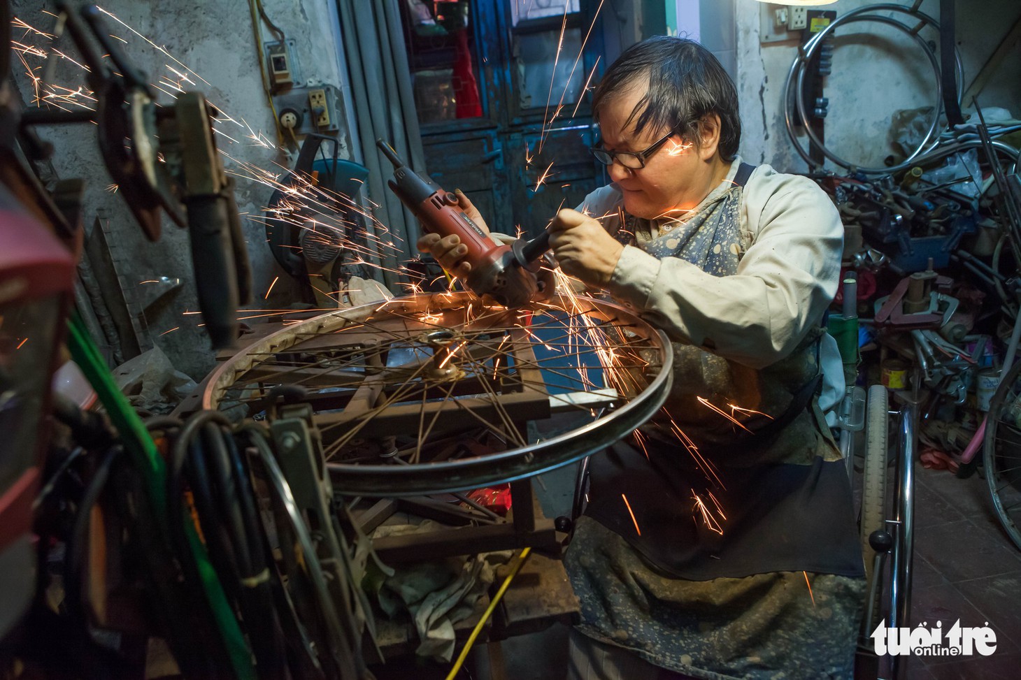 Người đàn ông ngồi xe lăn 20 năm làm xe cho người cùng cảnh ngộ - Ảnh 2.
