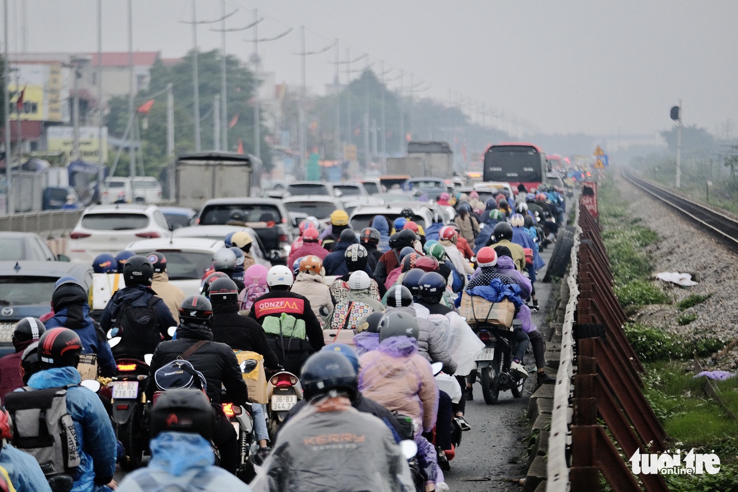 Người dân đội mưa trở lại Hà Nội mùng 6 Tết, cửa ngõ phía Nam ùn ứ kéo dài - Ảnh 7.