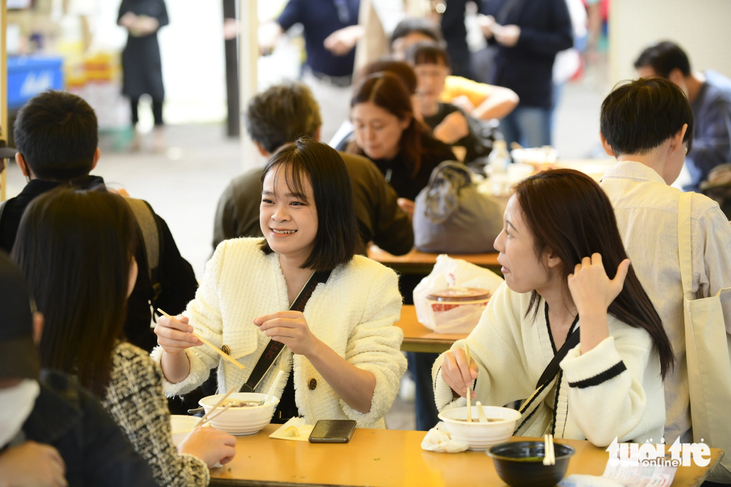 Nhóm bạn người Việt ở Tokyo thưởng thức phở nóng và trò chuyện vui vẻ trong tiết trời mát mẻ. Nhiều thực khách tấm tắc khen phở ở lễ hội rất ngon và đậm vị.