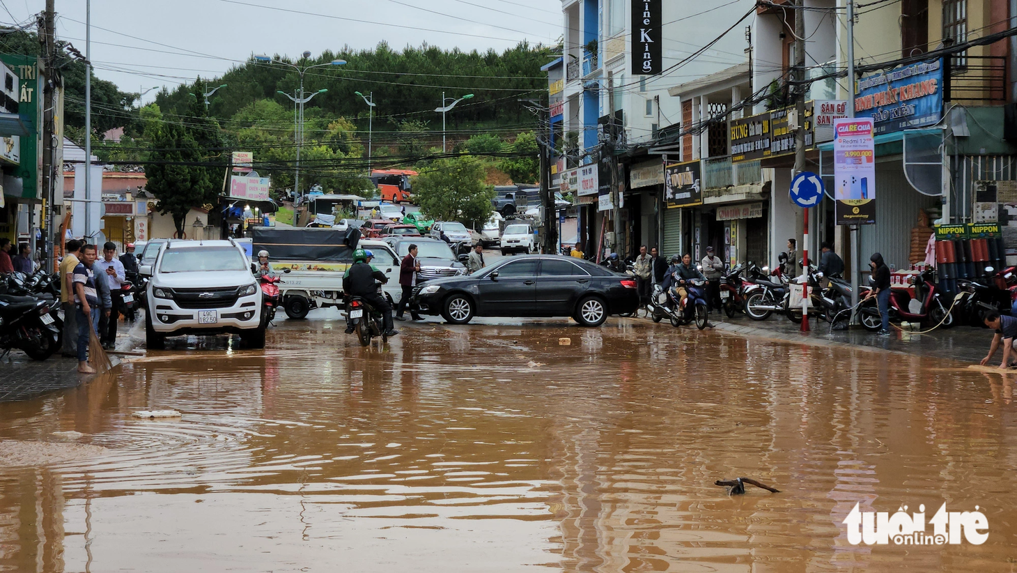 Người dân dùng xe chắn ngang để ngăn xe máy đi vào đoạn đường ngập, tránh nguy hiểm - Ảnh: M.V.