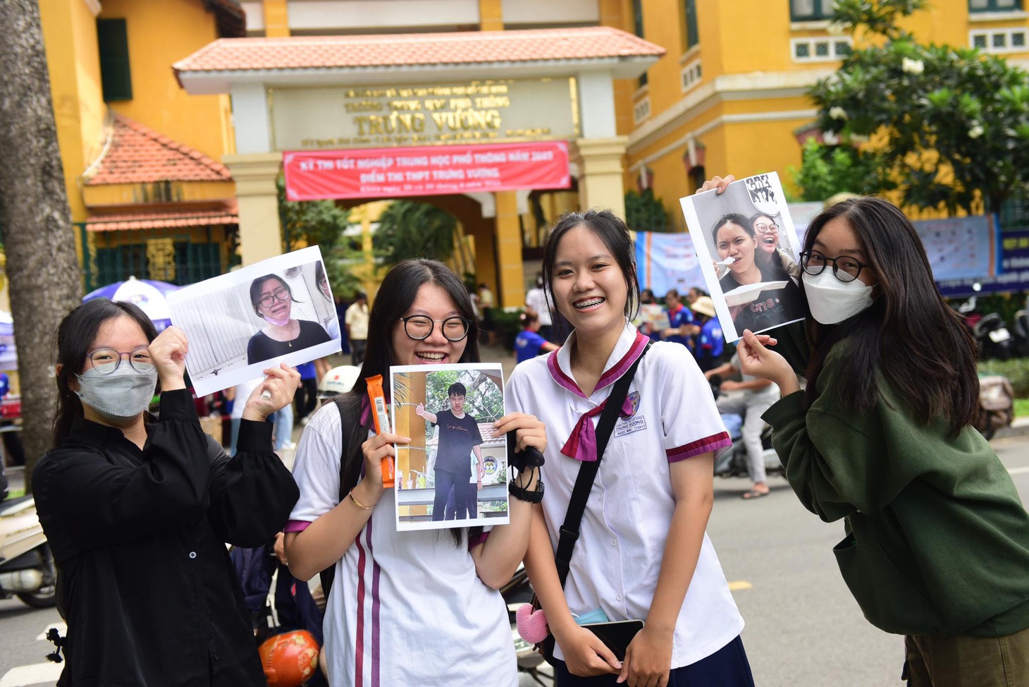 Hai bạn Uyên Khanh và Ngọc Mai được bạn cổ vũ khi đi làm thủ tục dự thi tại điểm thi THPT Trưng Vương, TP.HCM - Ảnh: DUYÊN PHAN
