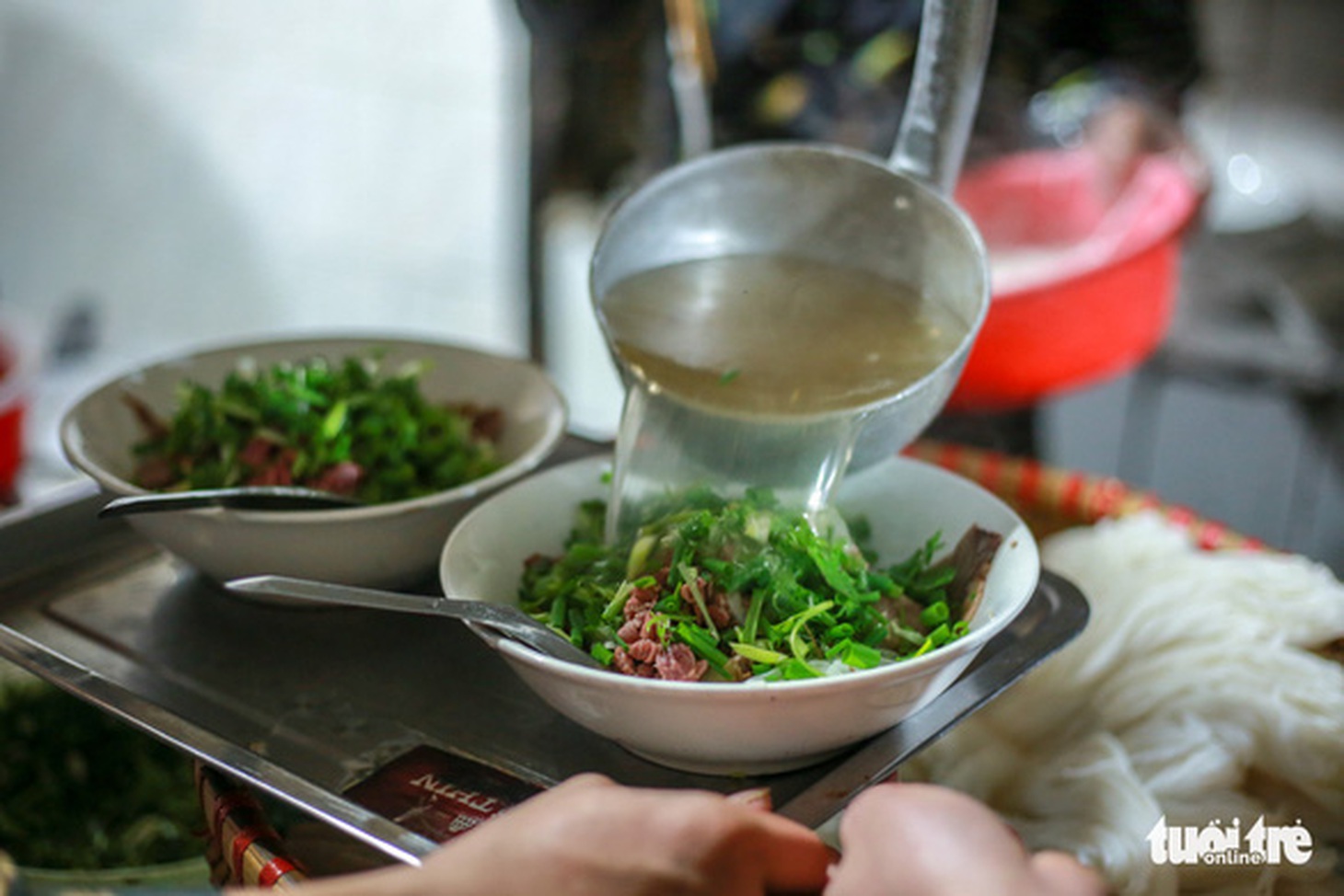 Thịt bò tái được làm chín bằng cách chan nước dùng nóng hổi - Ảnh: NAM TRẦN