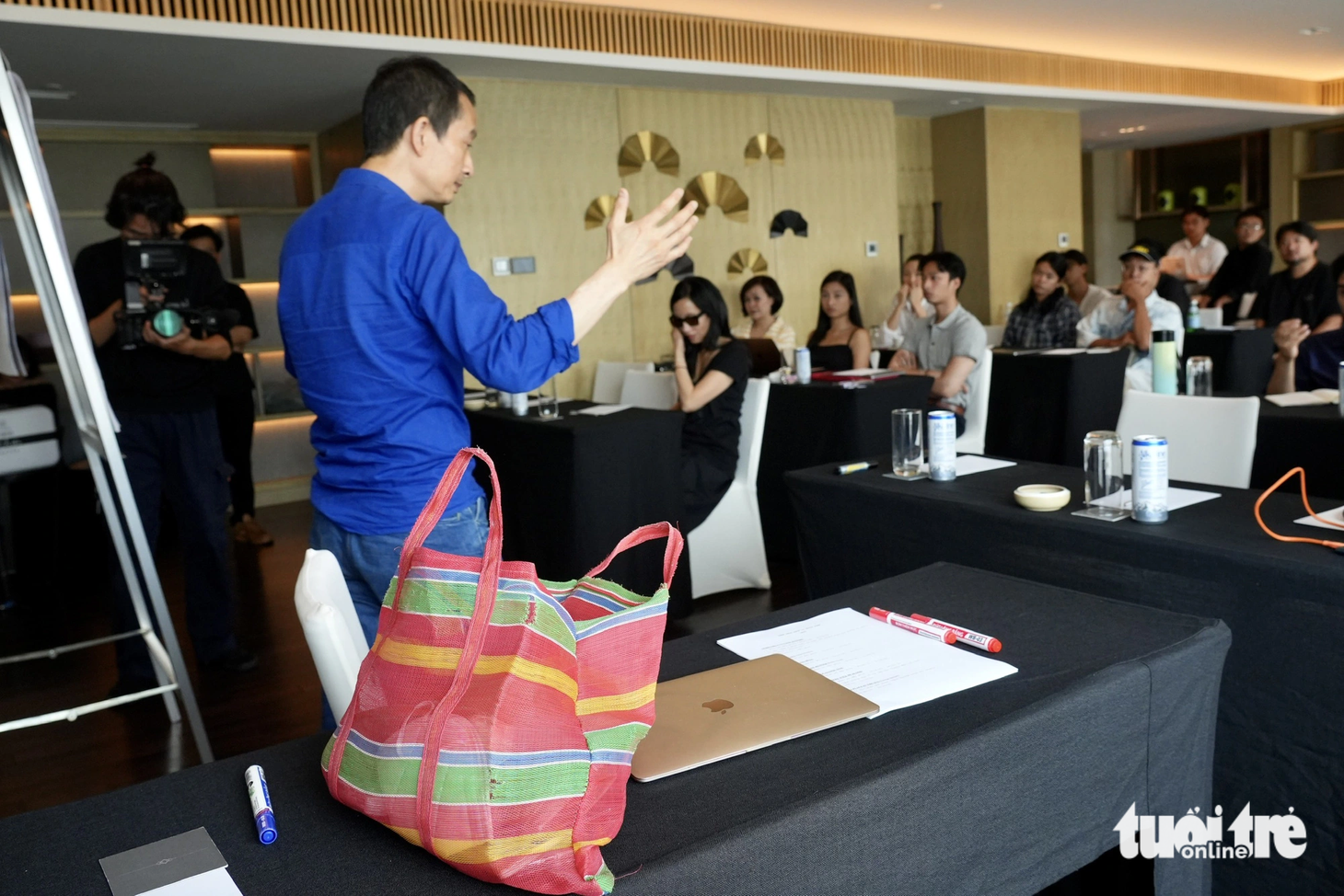 Đạo diễn Trần Anh Hùng mang theo một chiếc túi lưới khi đến với lớp học. Trong buổi workshop, anh chia sẻ những kinh nghiệm làm phim đáng quý, kể những câu chuyện và trả lời câu hỏi của học viên. Anh đã chuẩn bị rất kỹ cho bài giảng năm nay - Ảnh: HỮU HẠNH