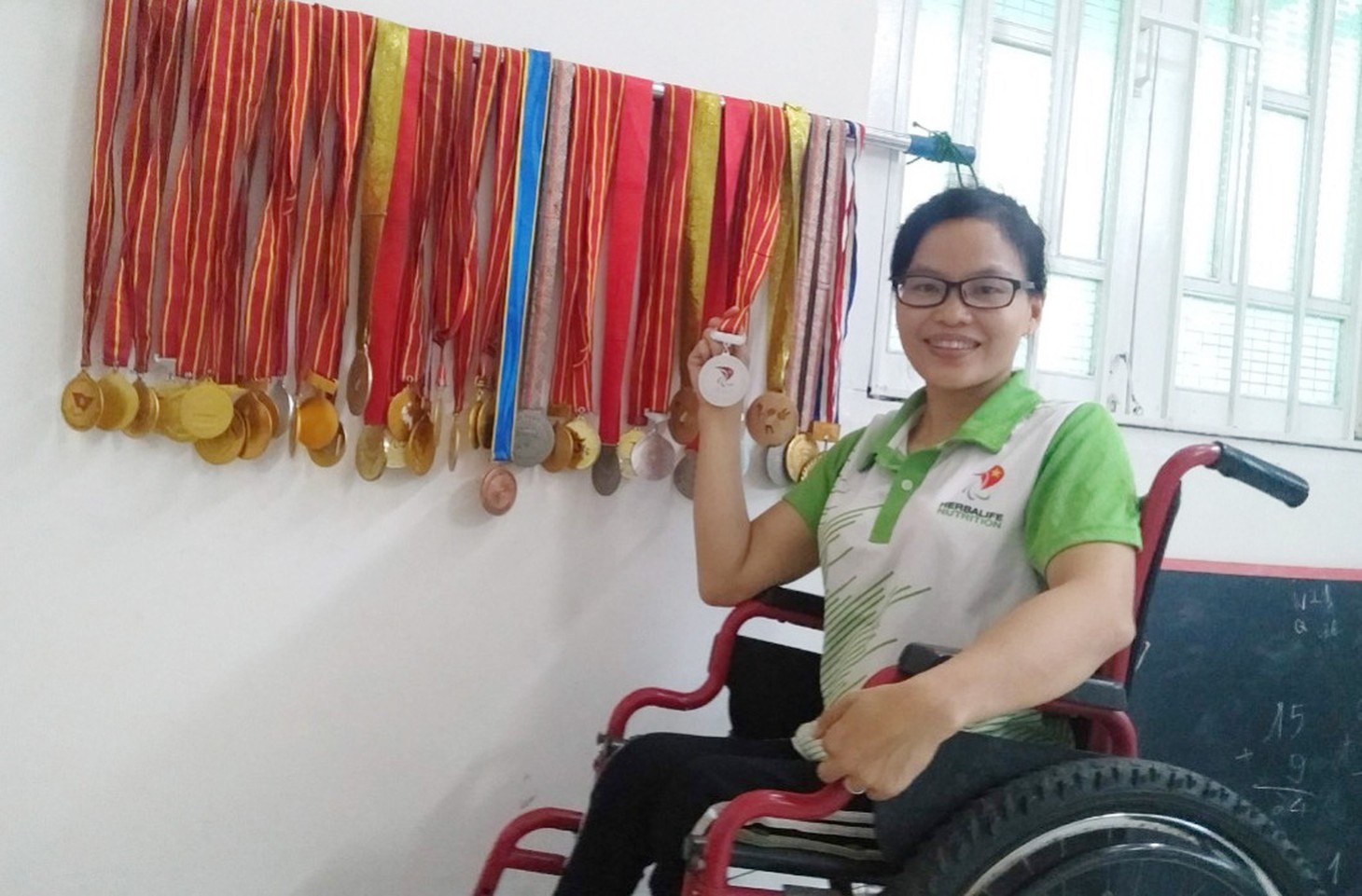 Kình ngư Nguyễn Thị Sari bên các huy chương mà chị đoạt được trong 16 năm thi đấu - Ảnh: NVCC