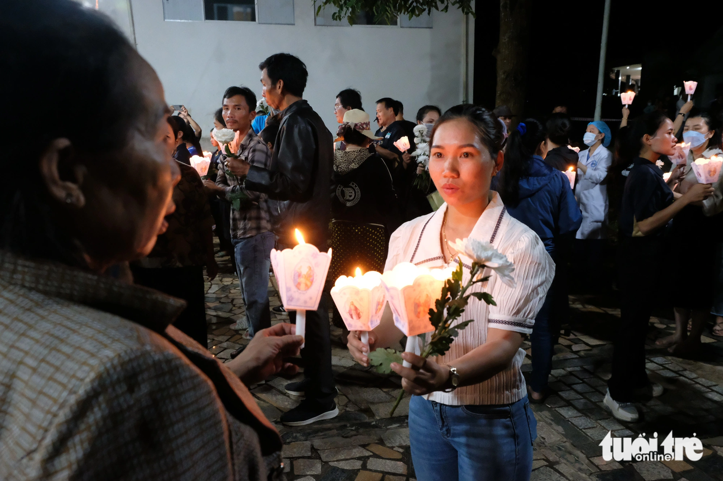 Mỗi người tham gia lễ tưởng niệm cầm một ngọn nến và một đóa hoa