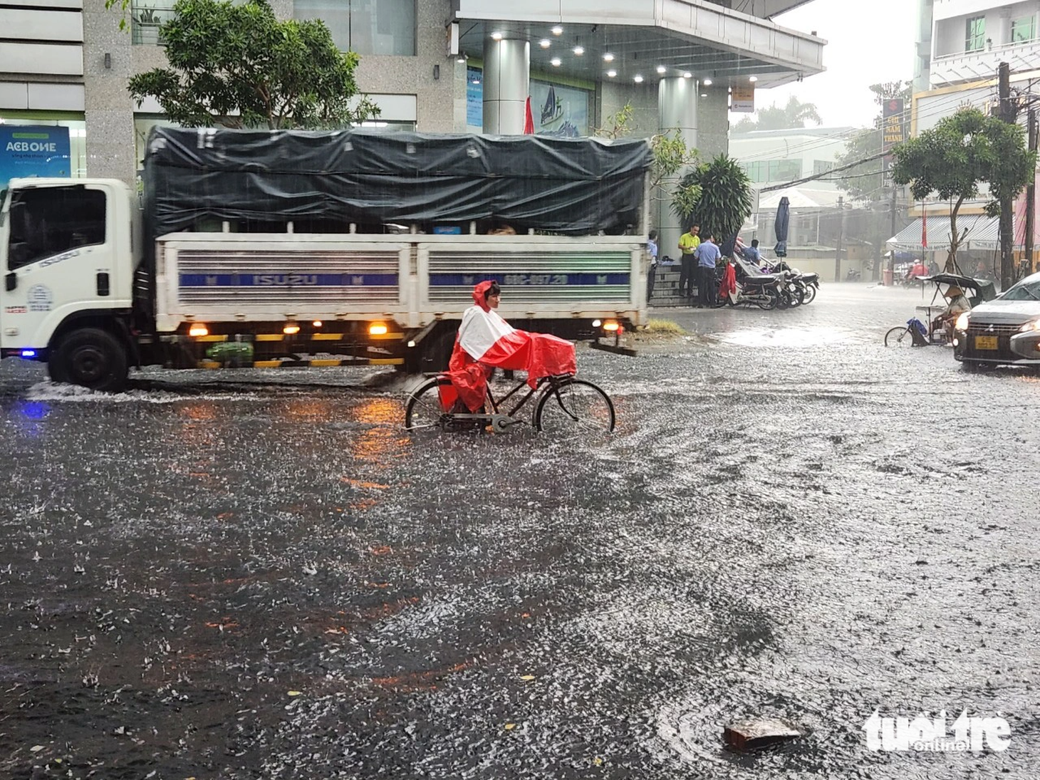 Người đi xe đạp phải dắt bộ vì nước ngập lớn - Ảnh: CHÍ HẠNH