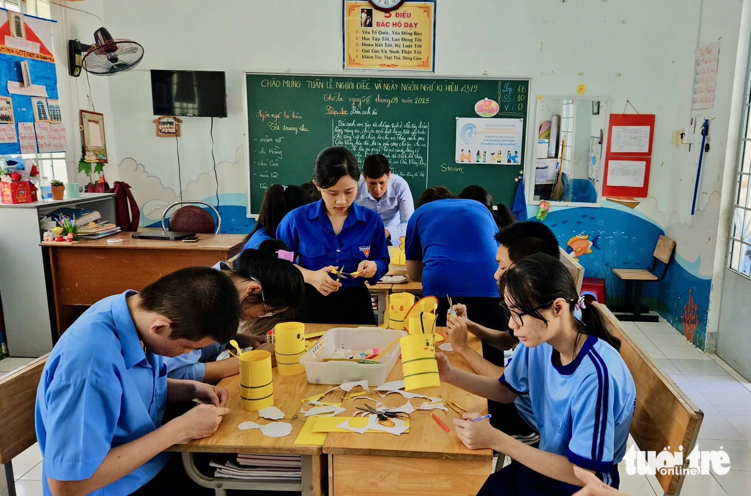 Các thành viên trong nhóm STEAM Nha Trang hướng dẫn các học sinh khuyết tật làm lồng đèn
