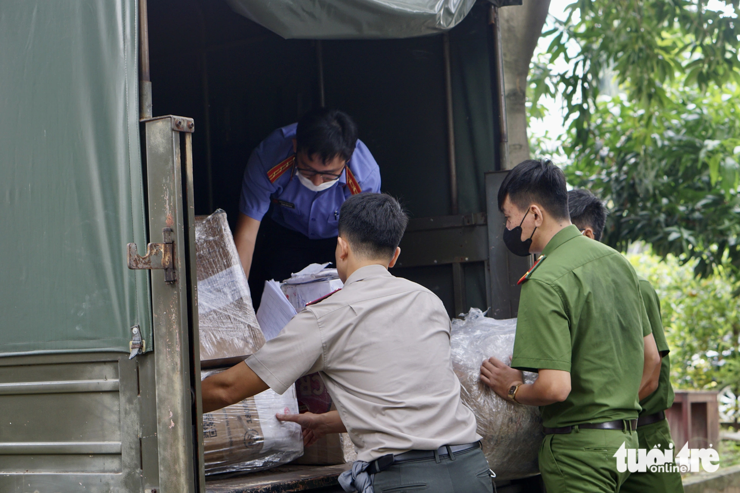 Lực lượng chức năng bốc xếp vật chứng lên xe đặc chủng để chở đến nơi tiêu hủy. Với số lượng ma túy lên đến hơn 1,6 tấn, lực lượng chức năng phải vận chuyển bằng hai xe đặc chủng - Ảnh: TUYẾT MAI