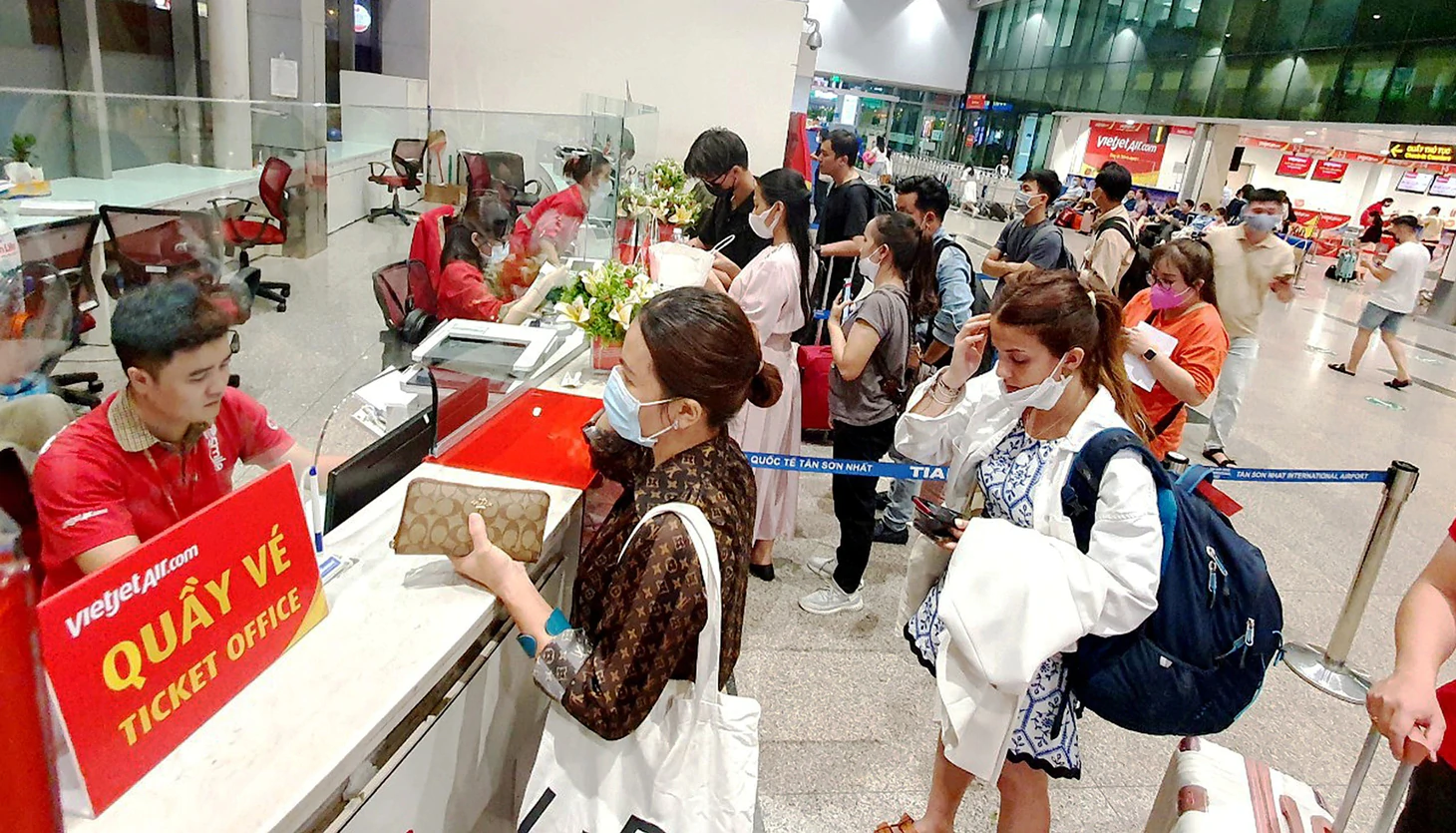 Hành khách mua vé máy bay tại quầy của Vietjet tại sân bay Tân Sơn Nhất, TP.HCM - Ảnh: CÔNG TRUNG