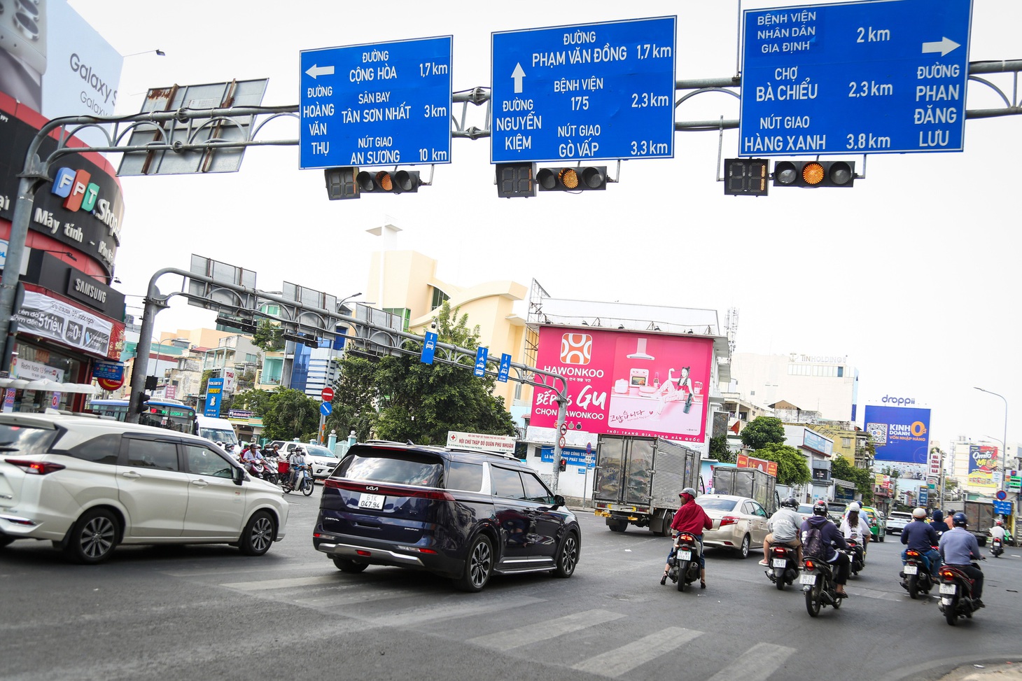 Xe nối đuôi nhau ráng vài giây vượt đèn vàng ở ngã tư Phú Nhuận trưa 23-1 - Ảnh: PHƯƠNG QUYÊN