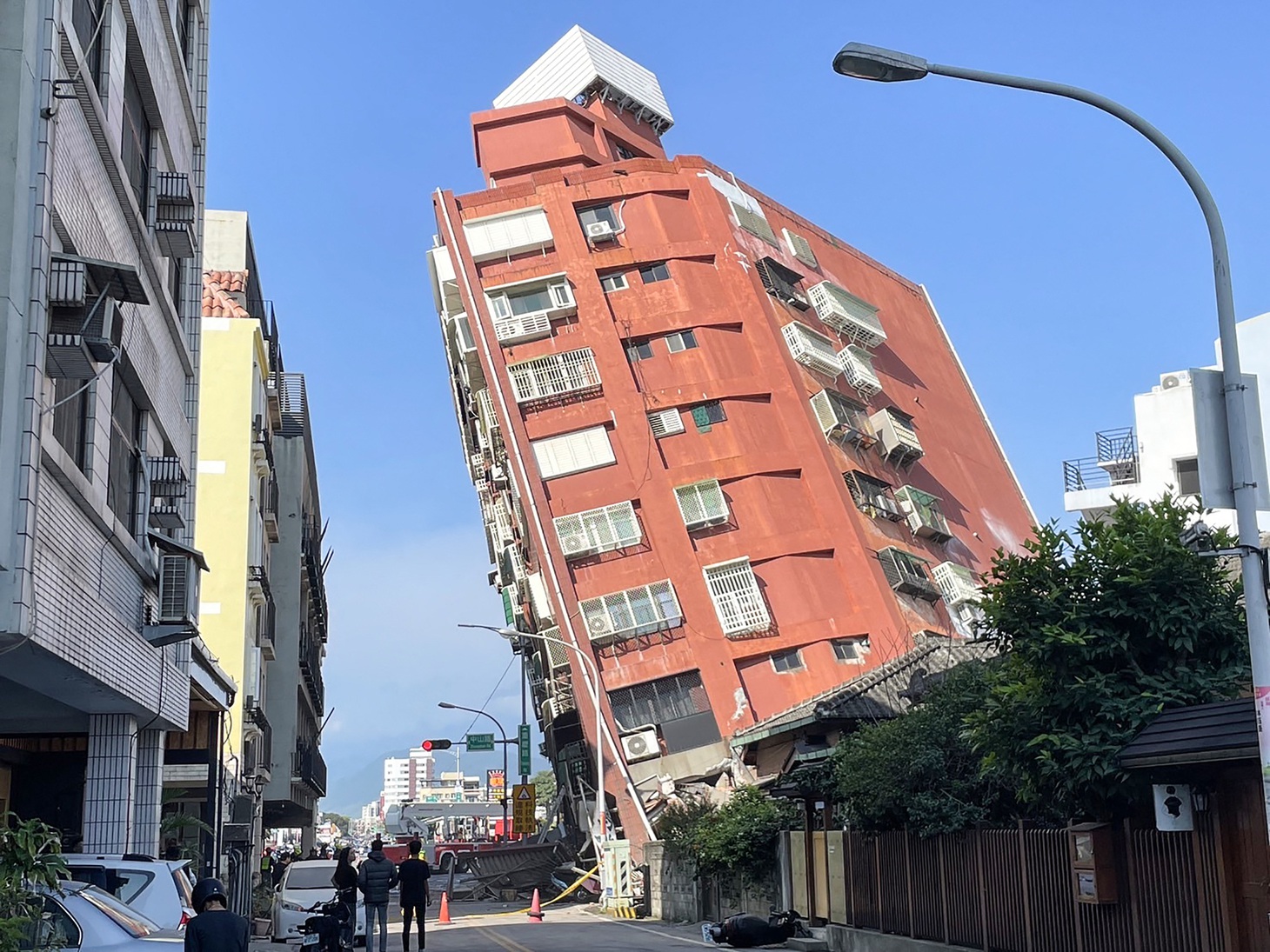 Người dân nhìn một tòa nhà đổ nghiêng do động đất ở thành phố Hoa Liên, Đài Loan ngày 3-4 - Ảnh: CNA/AFP