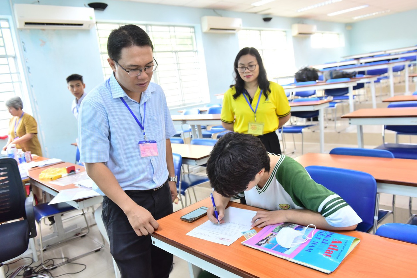 Tại điểm thi Trường ĐH Bách khoa, đến khoảng 7h30 ghi nhận 1 trường hợp quên giấy tờ thi, các thầy cô hỗ trợ làm giấy cam đoan trước khi vào phòng thi - Ảnh: DUYÊN PHAN