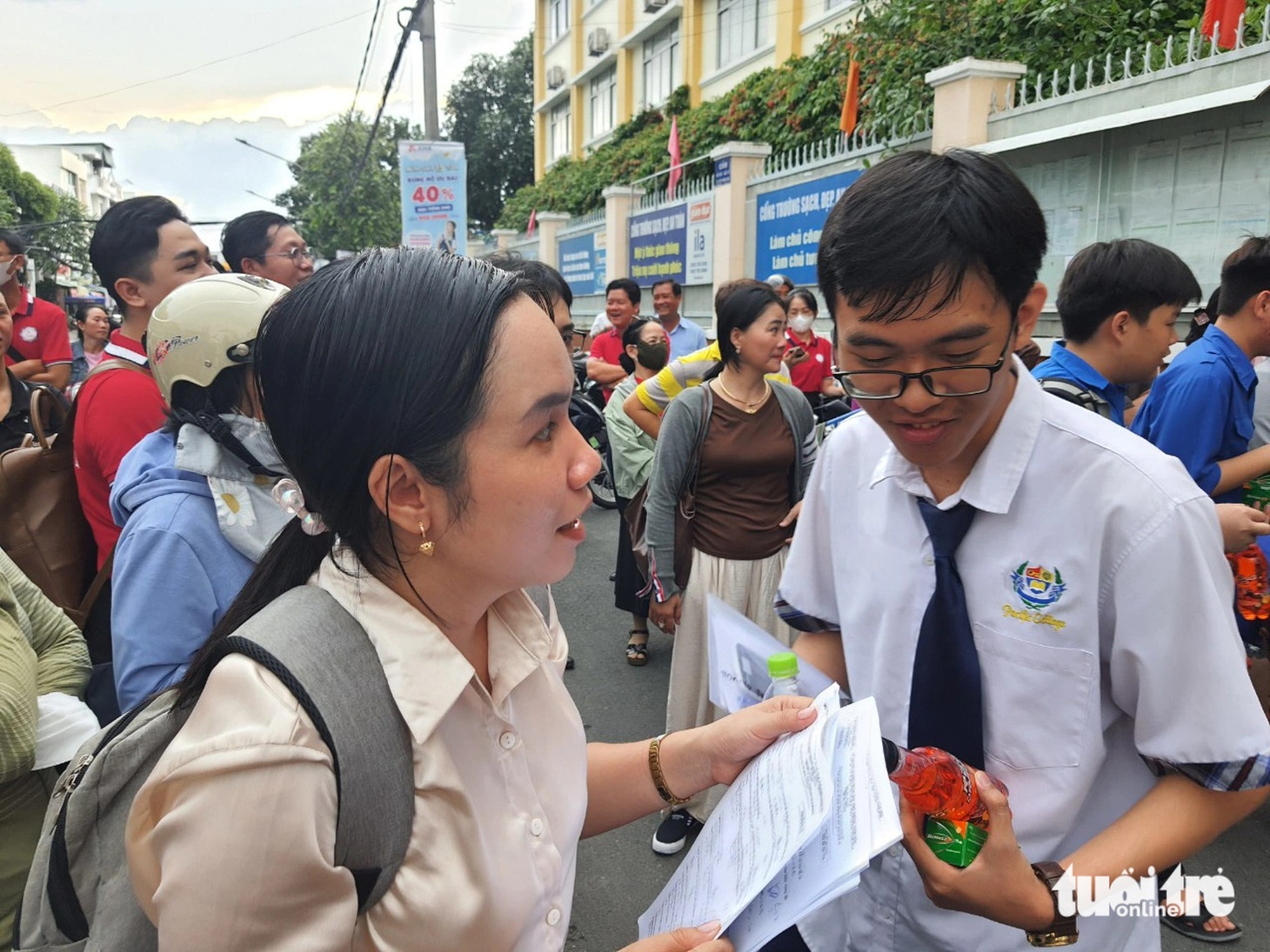 Giáo viên đón học sinh tại cổng điểm thi Trường Đoàn Thị Điểm (quận Ninh Kiều, TP Cần Thơ) để hỏi thăm tình hình làm bài thi môn toán - Ảnh:. T. LŨY