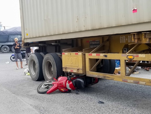 Xe container cuốn xe máy vào gầm làm một phụ nữ chết tại khúc cua nguy hiểm - Ảnh 1. Xe container cuốn xe máy vào gầm làm một phụ nữ chết tại khúc cua nguy hiểm - Ảnh 1.