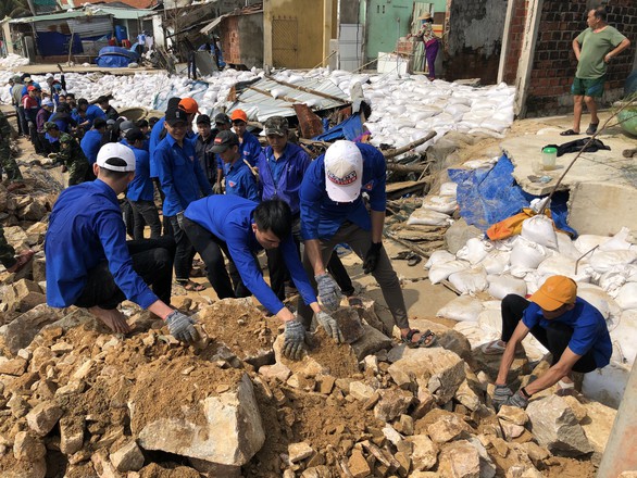 Thanh niên, bộ đội giúp dân dọn rác, vác đá vá bờ kè bị bão đánh sập - Ảnh 4. Thanh niên, bộ đội giúp dân dọn rác, vác đá vá bờ kè bị bão đánh sập - Ảnh 4.