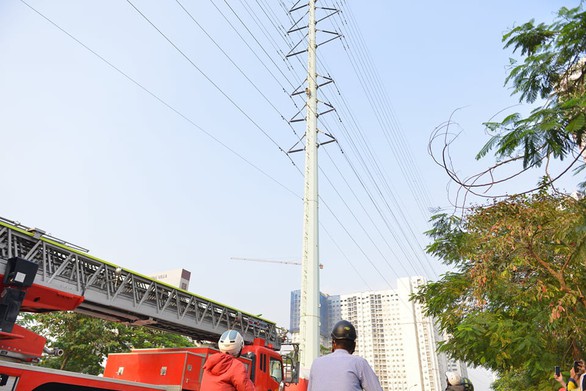 Cảnh sát đưa xe thang và đệm hơi ứng cứu thanh niên cố thủ trên cột điện cao thế - Ảnh 2. Cảnh sát đưa xe thang và đệm hơi ứng cứu thanh niên cố thủ trên cột điện cao thế - Ảnh 2.
