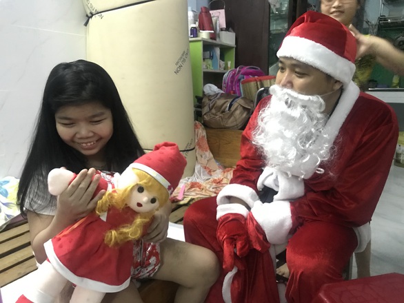 Ông già Noel cưỡi xe đạp len lỏi trong hẻm nhỏ tặng quà Giáng sinh - Ảnh 1. Ông già Noel cưỡi xe đạp len lỏi trong hẻm nhỏ tặng quà Giáng sinh - Ảnh 1.