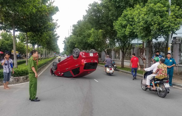 Xe hơi lật ngửa giữa đường, nữ hành khách nhập viện cấp cứu - Ảnh 1. Xe hơi lật ngửa giữa đường, nữ hành khách nhập viện cấp cứu - Ảnh 1.