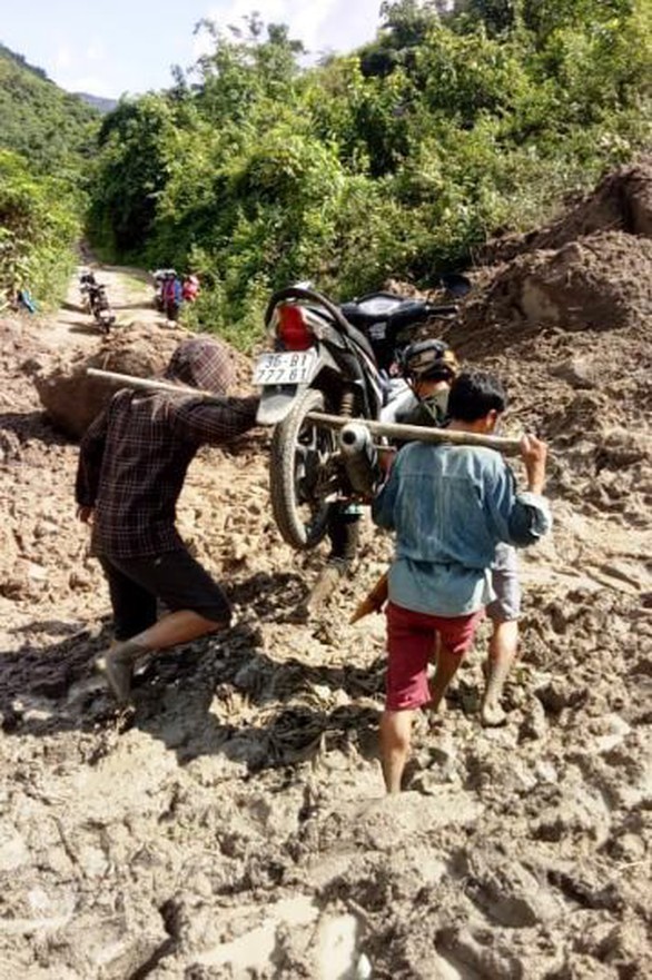 Thầy cô giáo gánh xe máy, lội bùn đến trường chuẩn bị năm học mới - Ảnh 1. Thầy cô giáo gánh xe máy, lội bùn đến trường chuẩn bị năm học mới - Ảnh 1.