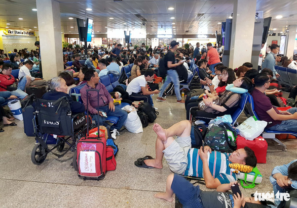 Máy bay liên tục hoãn chuyến, hành khách nằm, ngồi la liệt ở Tân Sơn Nhất - Ảnh 3.