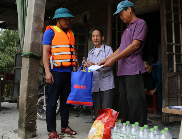 Bà con vùng lũ sẻ chia với nhau quà bạn đọc báo Tuổi Trẻ - Ảnh 9.