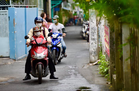 TP.HCM se lạnh, người dân khoác áo ấm, choàng khăn ra đường - Ảnh 3.