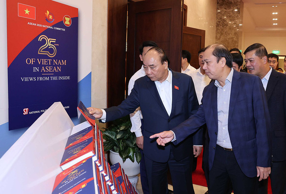 Thủ tướng Nguyễn Xuân Phúc - chủ tịch ASEAN 2020 - xem ấn phẩm phục vụ hội nghị - Ảnh: TTXVN