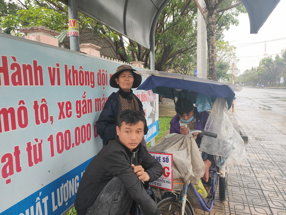 Những người già bán vé số đội mưa, co ro trong giá rét để mưu sinh - Ảnh 4.