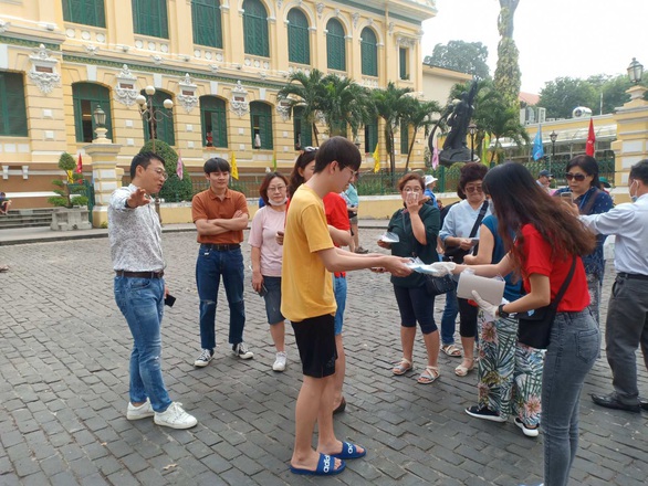 Du khách nước ngoài bất ngờ vì được phát miễn phí khẩu trang ở TP.HCM - Ảnh 1. Du khách nước ngoài bất ngờ vì được phát miễn phí khẩu trang ở TP.HCM - Ảnh 1.