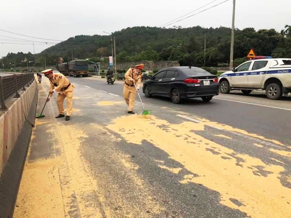 Cảnh sát giao thông và người dân giúp tài xế gom 4 tấn đỗ tương rớt xuống đường - Ảnh 4. Cảnh sát giao thông và người dân giúp tài xế gom 4 tấn đỗ tương rớt xuống đường - Ảnh 4.