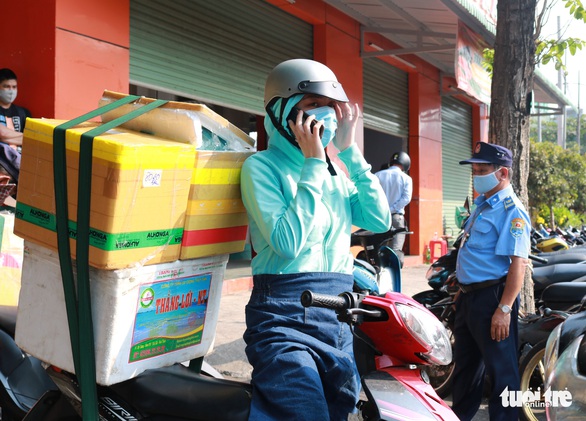 TP.HCM: Đổ xô nhận tiếp tế từ gia đình trong ngày đầu hạn chế đi lại - Ảnh 1. TP.HCM: Đổ xô nhận tiếp tế từ gia đình trong ngày đầu hạn chế đi lại - Ảnh 1.